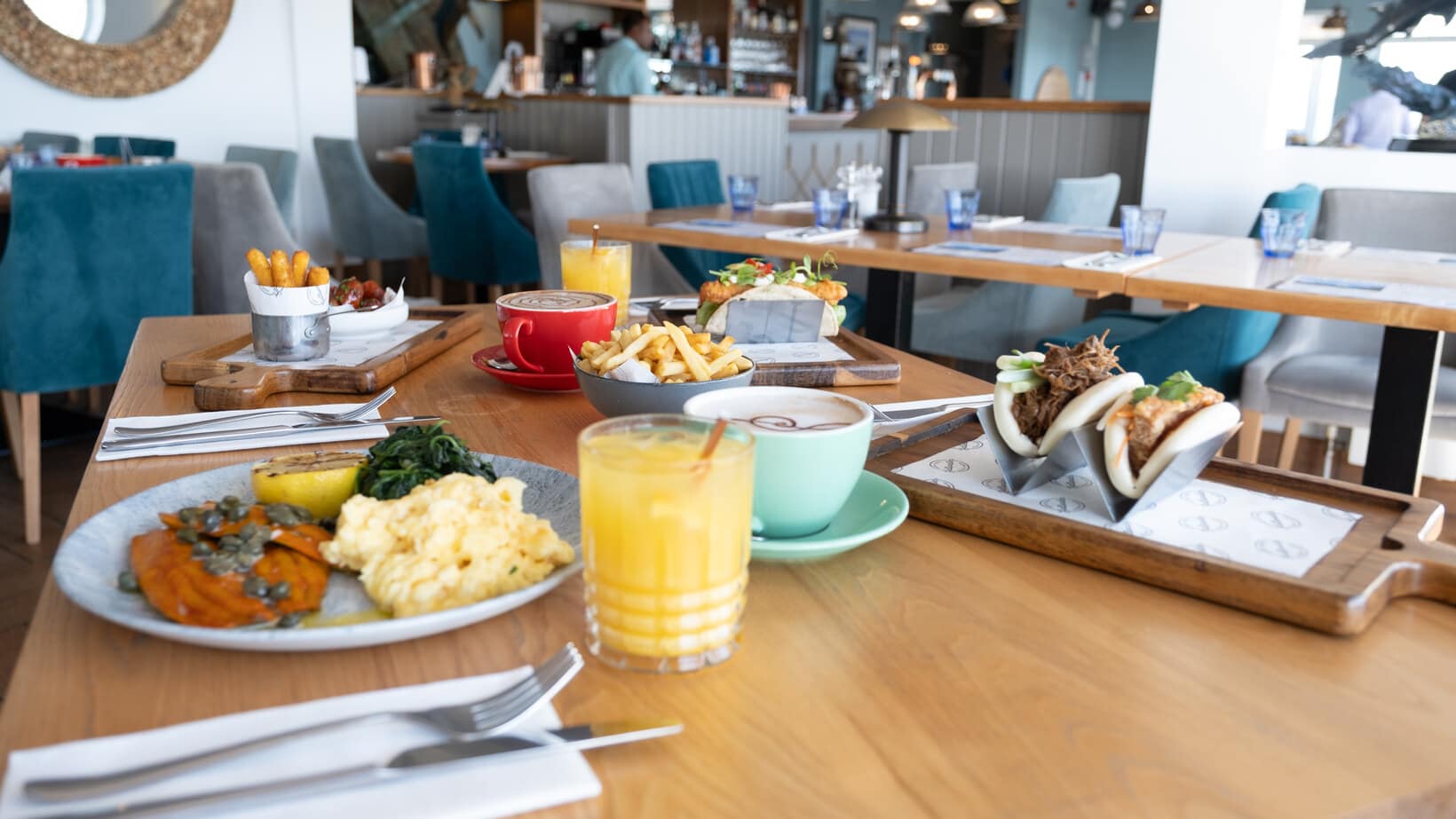 Brunch dishes, coffee and fresh orange juice on a table inside Saltwater